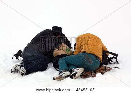 NGARI, TIBET - MAY 6, 2013: Two Tibetan pilgrims sleeping over snow during snowstorm on the trail around sacred mount Kailash in Ngari Prefecture, Tibet Autonomus Region of China.