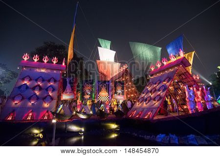 KOLKATA INDIA - OCTOBER 21 2015 : Beautiful exterior of decorated Durga Puja pandal at night Howrah West Bengal India. Shot under colored lights. Durga Puja is biggest religious festival of Hinduism.