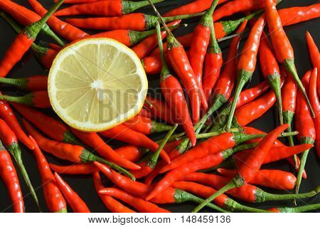 sliced lemon and chili on black background