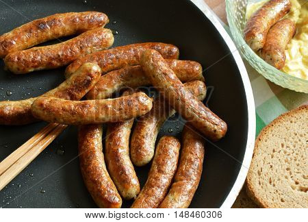 fried german sausage in pot with bread