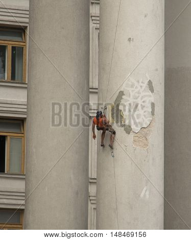 Industrial climber talking on the phone at the height of