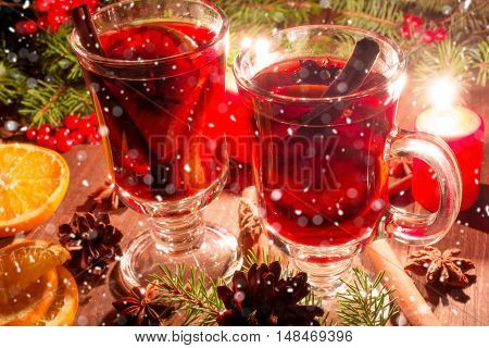 christmas mulled wine with spices and orange in the candle light with snow texture. festive romantic drinks background