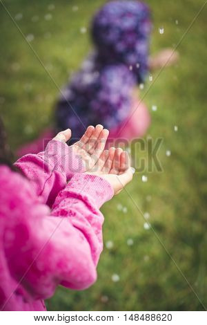 A young girl is feeling hail for the first time after a massive storm.