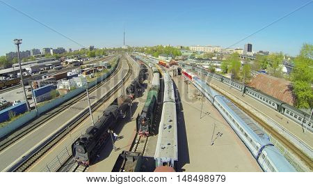Retro and modern trains at a railway station on a sunny spring day, aerial view
