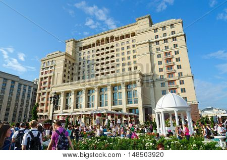 MOSCOW RUSSIA - JULY 23 2016: Unidentified people are on Manezhnaya square near Four Seasons Hotel Moscow 5* (previously - hotel "Moscow") during holiday Moscow Russia