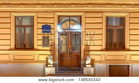 Two windows and door in a row on night illuminated facade of urban office building front view St. Petersburg Russia