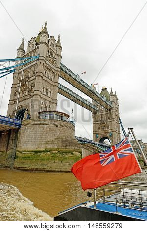 Tower Bridge with thebritis flag a combined bascule and suspension bridge in London England built in 1886-1894. It has become an iconic symbol of London.