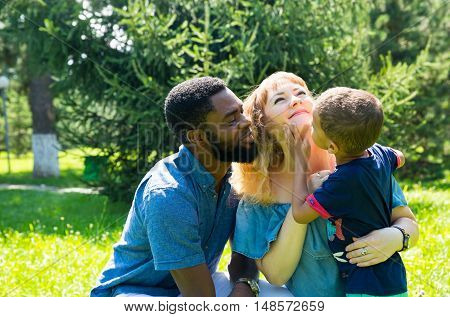 African American happy family: black father mom and baby boy on nature. Use it for a child parenting or love concept