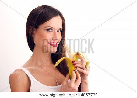 Attractive Woman eats RAW food fruit banana white background