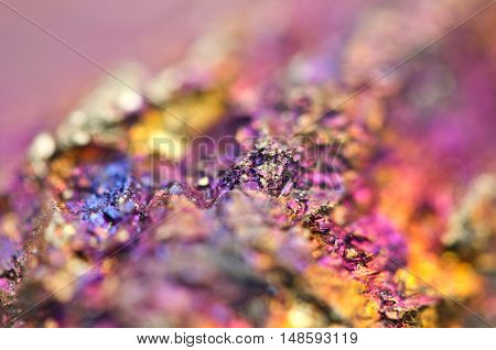 Bornite ore crystallizes mineral its blurred natural background. Macro. Focus on the central. Very shallow depth of field