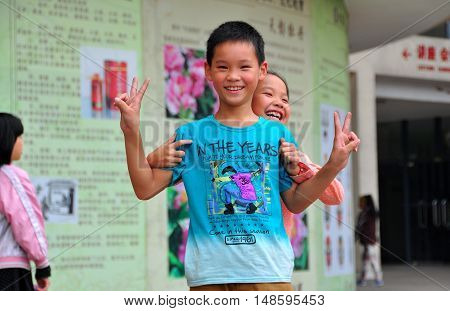Pengzhou China - October6 2013: Two smiling Chinese children flash the 