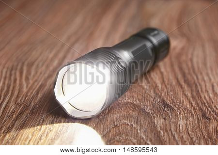 diode flashlight on a wooden background glare light