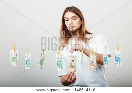 Riches and fortune. Young happy man with a lot of money on grey background. Winning the lottery concept.