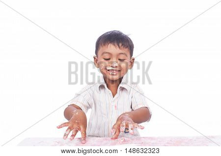 little boy happy play cream cake on white backgrond