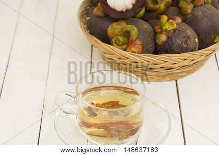 Mangosteen juice from herbs and mangoteen  in the basket on wooden white background.Top view and zoom in.