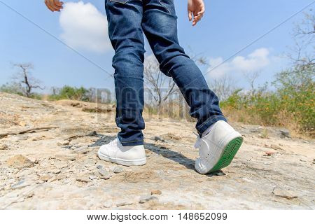 Boy Walking On The Rocky Land.