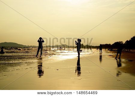 Silhouette of many people standing on the beach