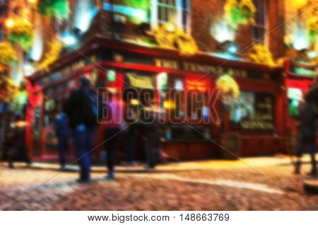 Blurred travel backgrounds - Nightlife at popular historical part of Dublin, Ireland - Temple Bar quarter. The area is the location of many bars, pubs and restaurants. People walking inside a pub