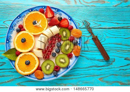 Fruit salad breakfast orange banana kiwi berries ow turquoise table