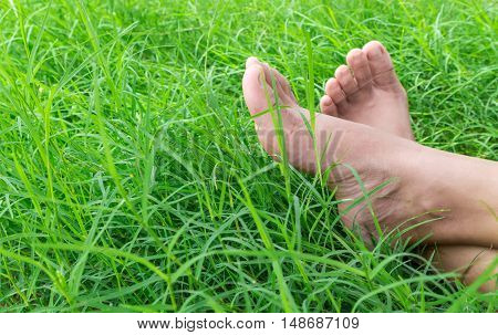 Woman bare feet on green grass relax and holiday concept