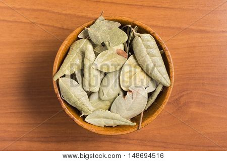 Brazilian Boldo Leaves into a bowl over a wooden table