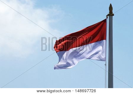 The red and white flag of Indonesia or Monaco waving when blown by the wind.