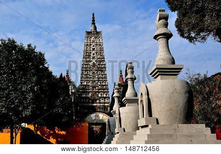 Pengzhou China - October 31 2013: A row of ornamental 
Tibetan dagobas and center Pagoda with glass niches containing Buddha statues at the Long Xing Monastery