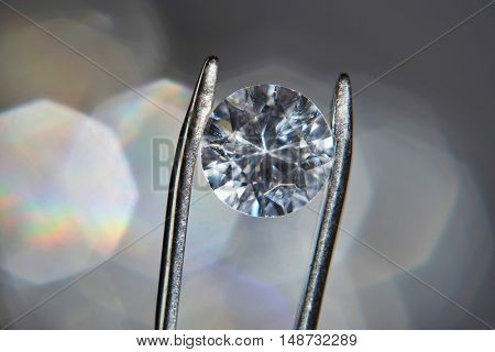 Diamond held by tweezers, close-up