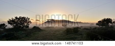 Landscape with fog and mountains on a cold winter morning