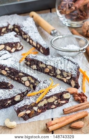 Panforte traditional italian christmas dessert with nuts and candied fruits on parchment vertical