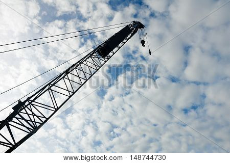 Abstract Industrial background with construction cranes above blue sky