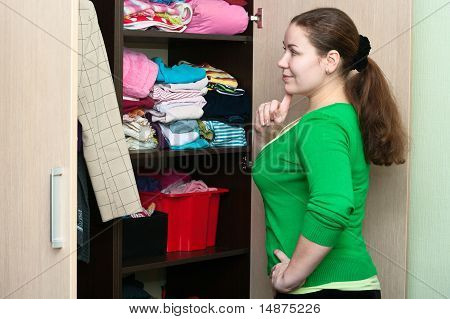 สาวคอเคซัสในตู้เสื้อผ้าชุดสิ่งบนมี Shelfs
