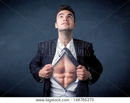 Businessman tearing off his shirt and showing mucular body concept on background