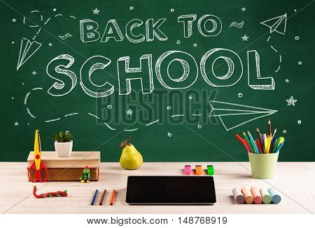Back to school concepty with writing on blackboard and desk, apple, books, items