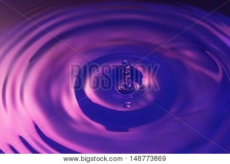 Water drop abstract in dark blue and purple hues.