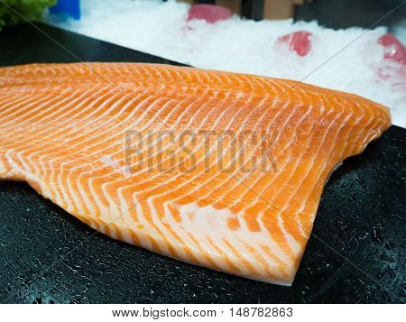 Raw salmon on the black shelf in the supermarket