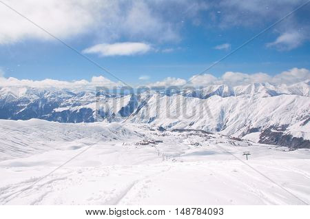 Bird view on the ski village in valley. Background of snowboard resort from the high peak. Winter season for advertising or billboard
