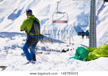 Ski paragliding prepairing for fly. Extreme sport in high mountains on snowboard resort. Happy sport and health life.