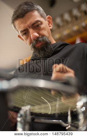Tennis Stringer Holding Awl And Doing Racket Stringing