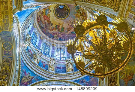 SAINT PETERSBURG RUSSIA - APRIL 25 2015: The amazing great dome of St Isaac's Cathedral decorated with frescoes golden patterns and sculptures on April 25 in Saint Petersburg.