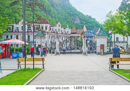 BORJOMI GEORGIA - MAY 26 2016: The gate of Mineral Water Park with the mansions of old town on the background on May 26 in Borjomi.