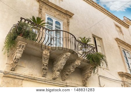 Balcony with baroque decorations in a house of Syracuse (Sicily)