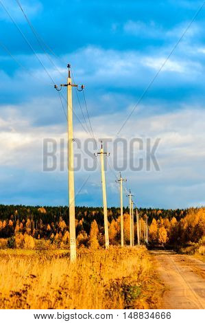 high voltage poles along the road an autumn day