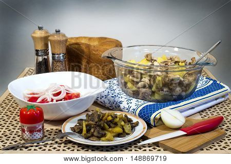 Fried potatoes with mushrooms, salad of fresh tomatoes and homemade bread for lunch