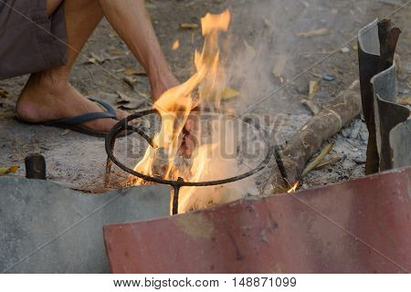 Hand of man try to fire by dry wood in winter period of north of Thailand.In countryside.
