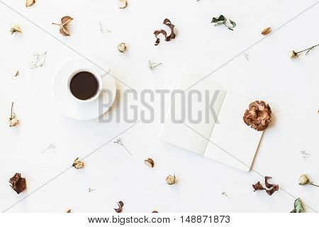 Autumn composition. Workspace with notebook cup of coffee autumn leaves and dried flowers. Top view flat lay