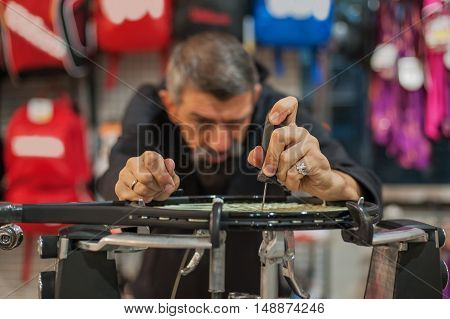 Tennis Stringer Holding Awl And Doing Racket Stringing