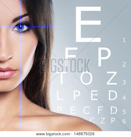 Beautiful woman with eye scanning over grey background.