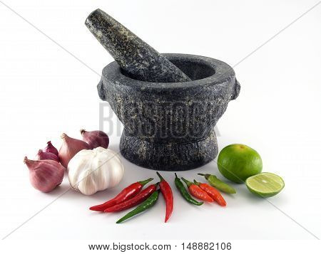 close up black stone granite mortar with pestle and variety colorful organic spices vegetables isolated on white background, prepare kitchenware and ingredients for thai food cooking