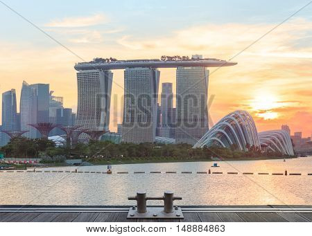 Singapore, Republic of Singapore - May 4, 2016: Supertree grove, Cloud garden greenhouse and Marina Bay Sands hotel reflecting in water at sunset
